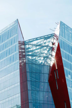 A sleek modern financial district building bathed in an elegant red hue representing strength and trust.