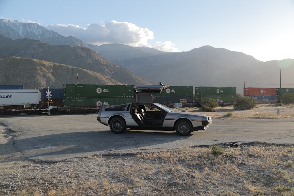 grey coupe near cargo trailers