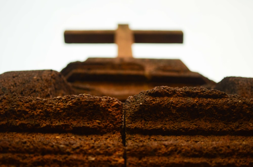 a close up of a brick wall with a cross in the background