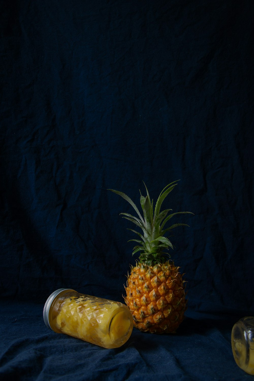 pineapple fruits near glass jars