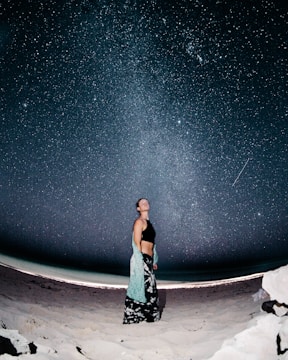 woman standing on sand at night