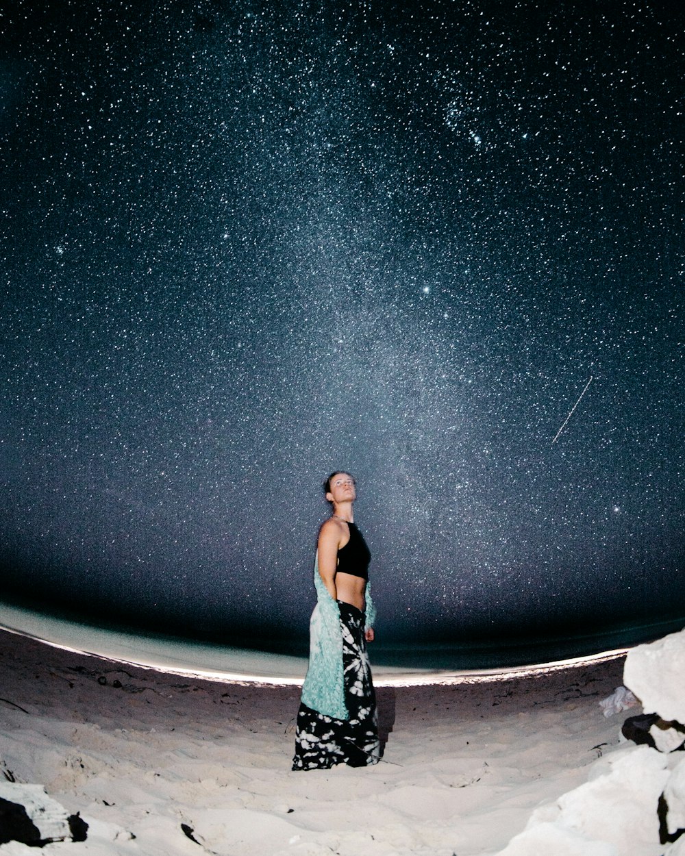 woman standing on sand at night
