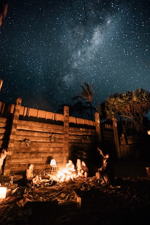 Guests enjoying a cozy bonfire night under the starry desert sky.