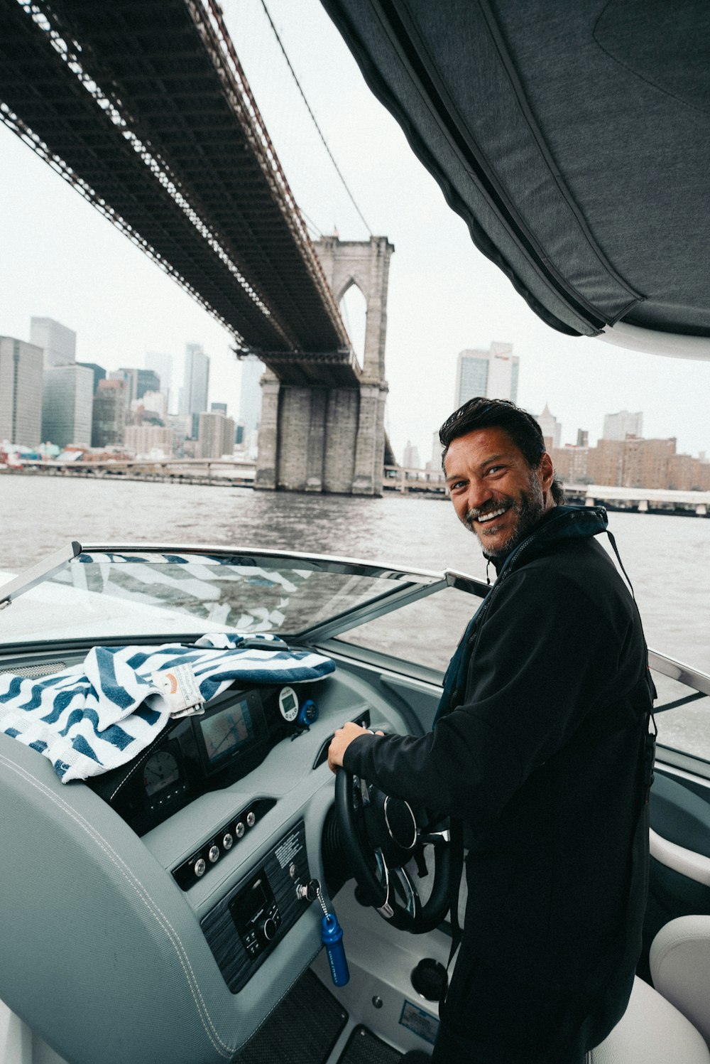 man standing and holding ship steering wheel