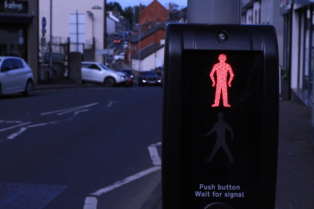 a red pedestrian walk sign on a city street