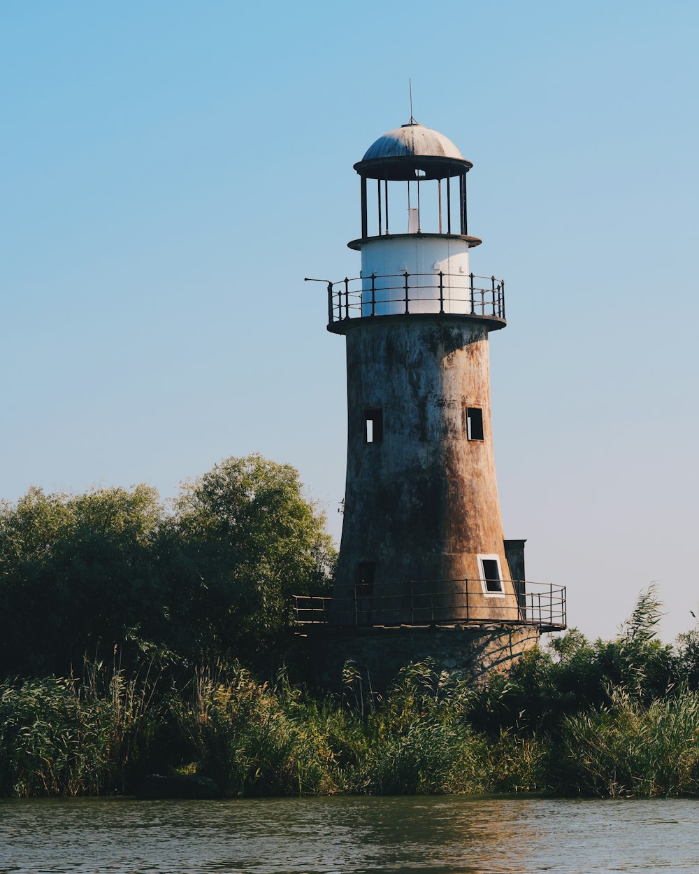 a light house sitting on the side of a river