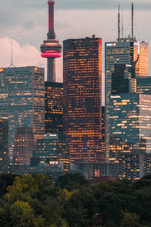 Toronto skyline at dusk with a subtle dark gradient overlay, reflecting the city where Zimmr Immigration is headquartered.