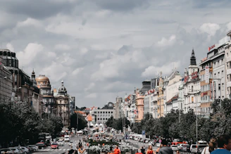 Historic Washington, D.C. street scene with vintage buildings and bustling pedestrians under a cloudy sky.