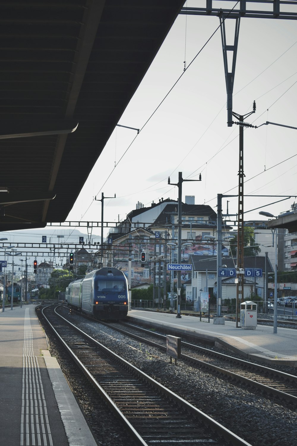 white and blue train near buildings during daytime