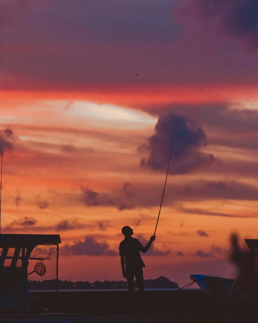 a man standing on top of a boat holding a fishing pole