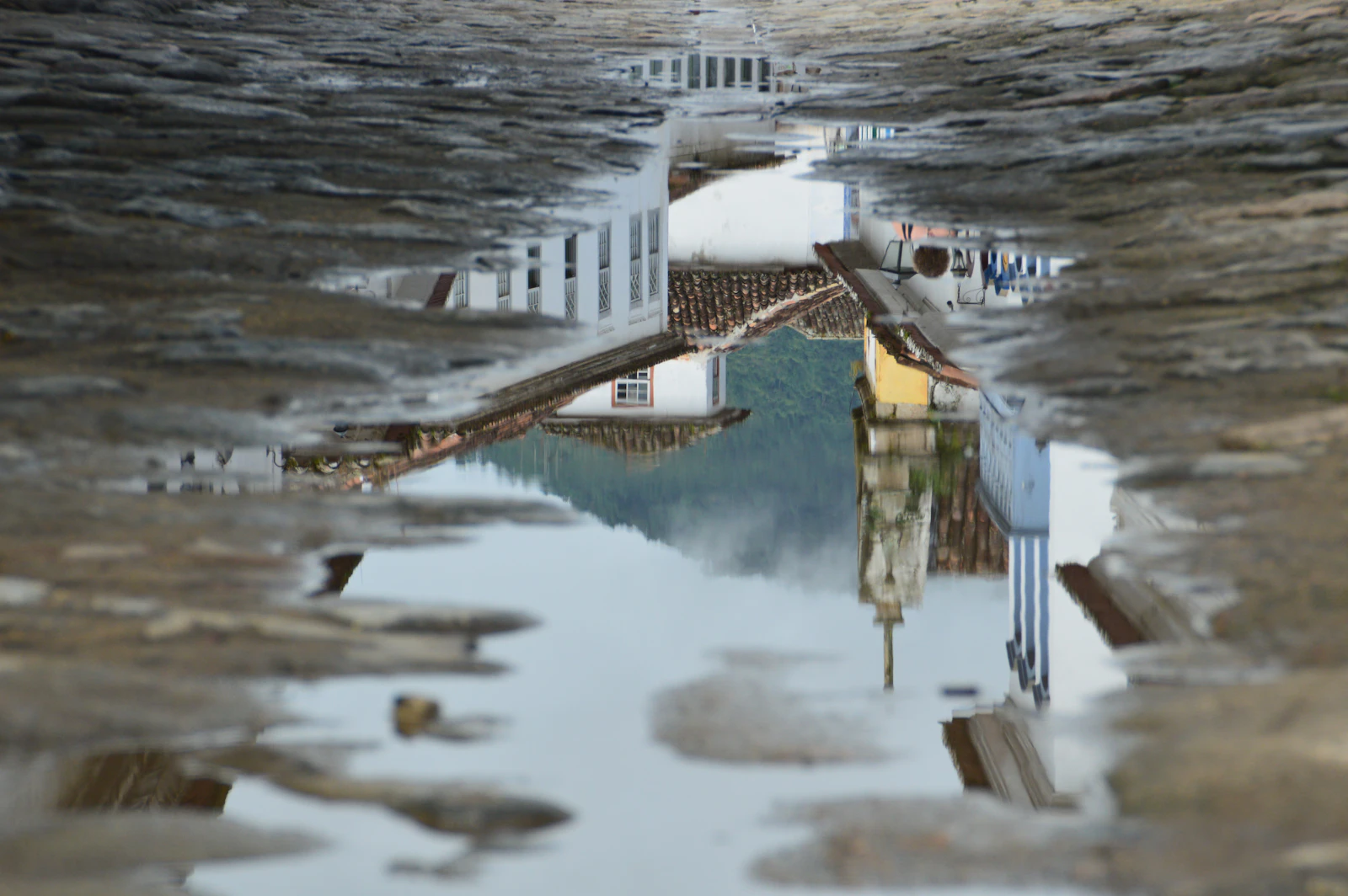 Colonial buildings reflected in a wet street in Paraty