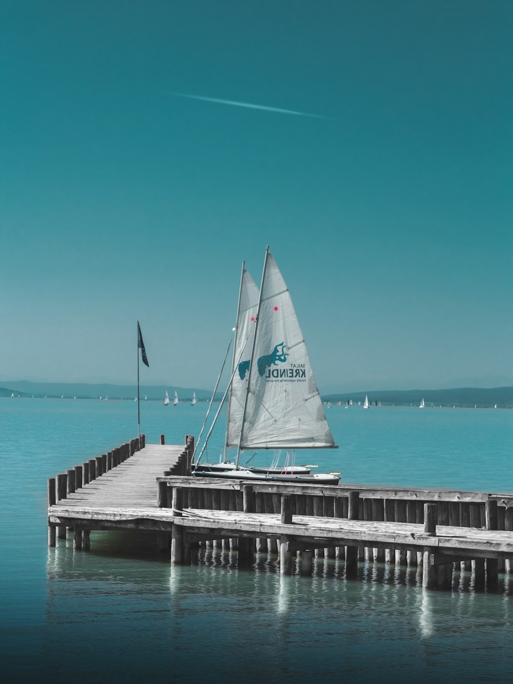 Tagsüber zwei Boote neben grauem Holzsteg