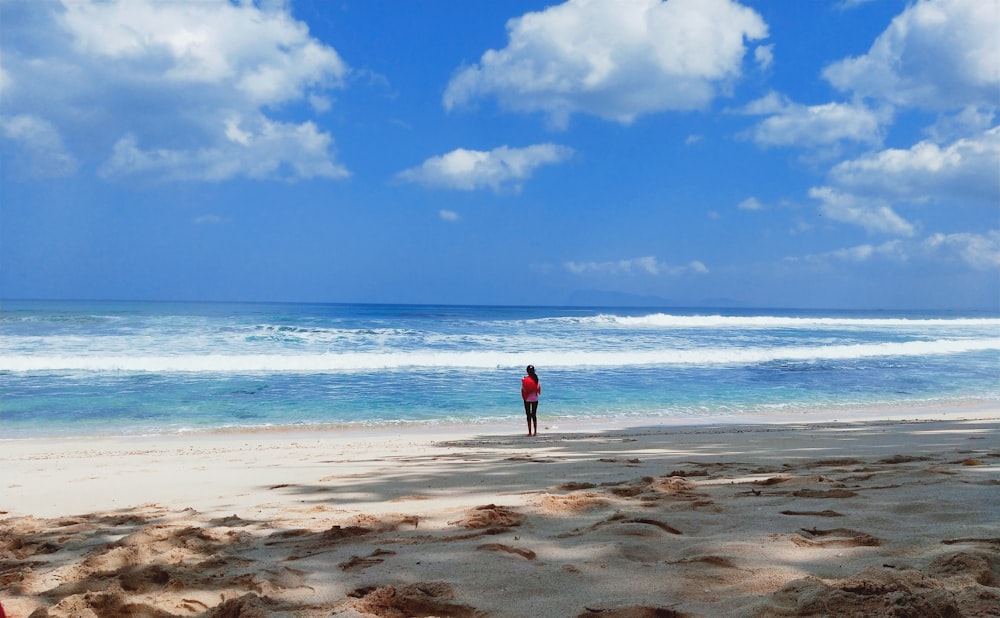 woman standing on shore at daytime