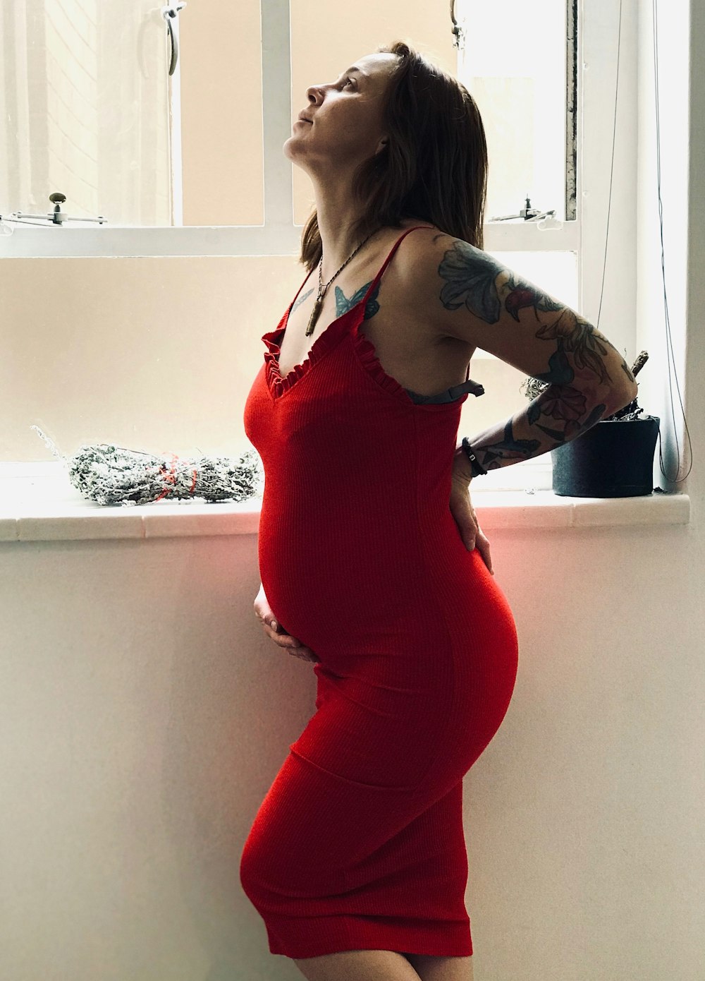 pregnant woman standing near window