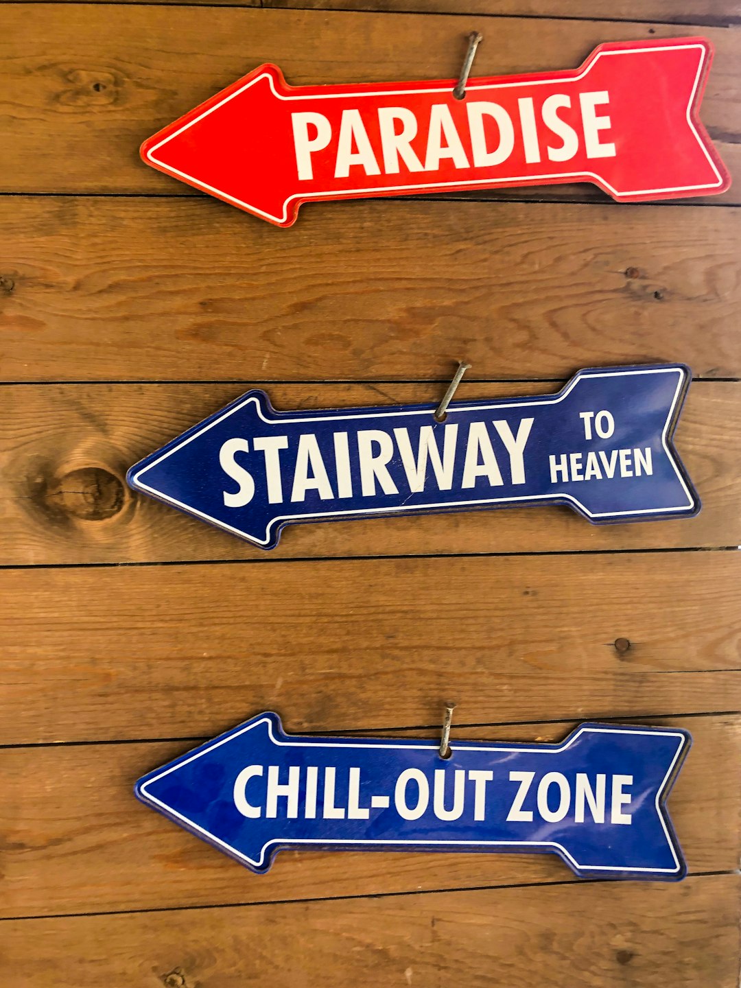 three assorted arrows signage on brown surface