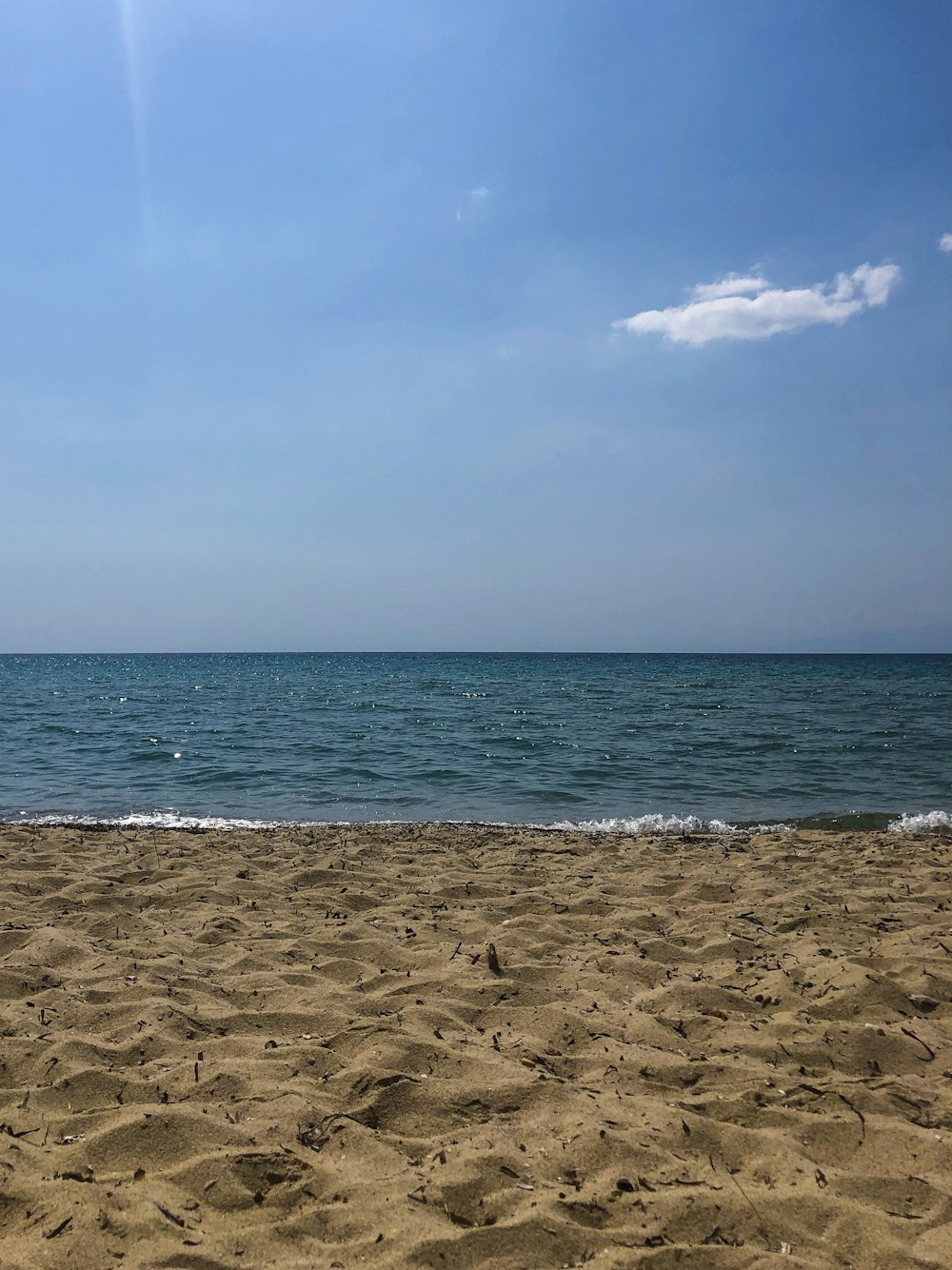 blue body of water under blue and white skies during daytime