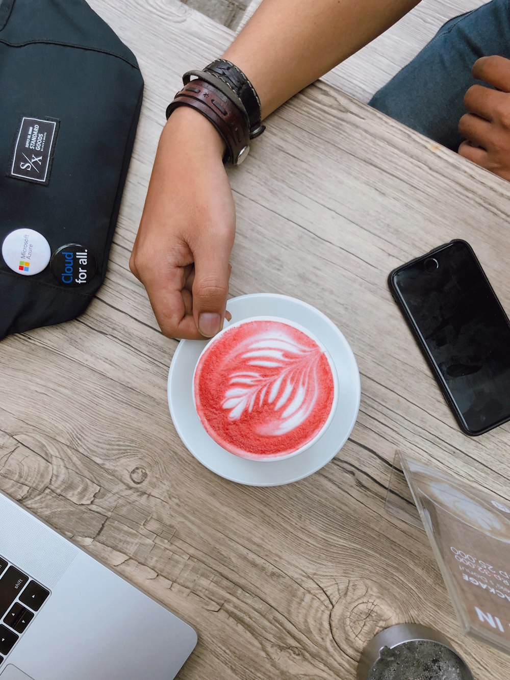 red cappuccino in mug near iPhone and MacBook