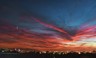 An artistic depiction of a vibrant sunset over a city skyline.