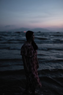 woman standing on body of water at daytime