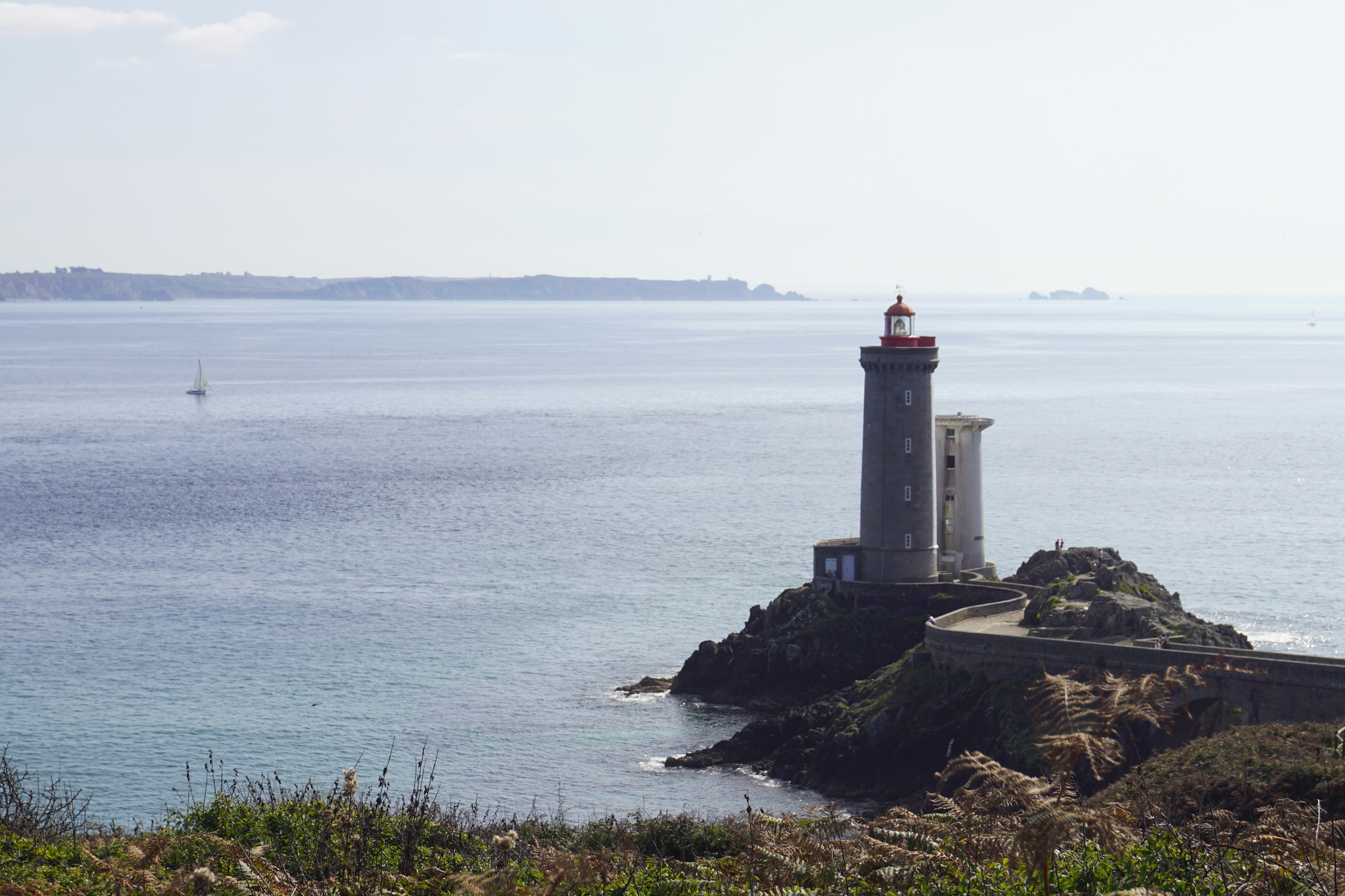 grey concrete lighthouse near body of water during daytime