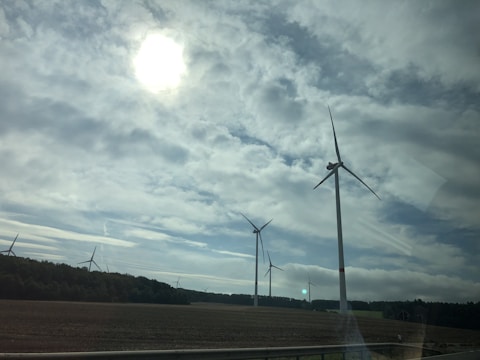Wind turbines standing tall against a cloudy sky on the rugged Vlašić plateau.