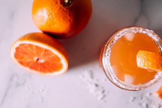 A chilled glass of sparkling mimosa with fresh orange slices on the rim.