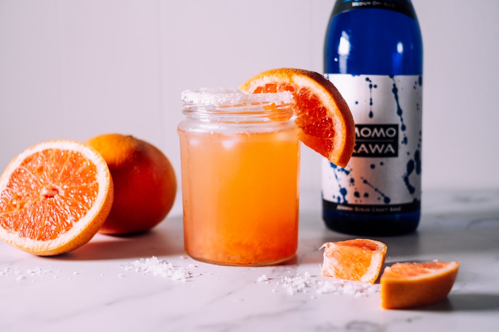orange juice in clear glass mason jar