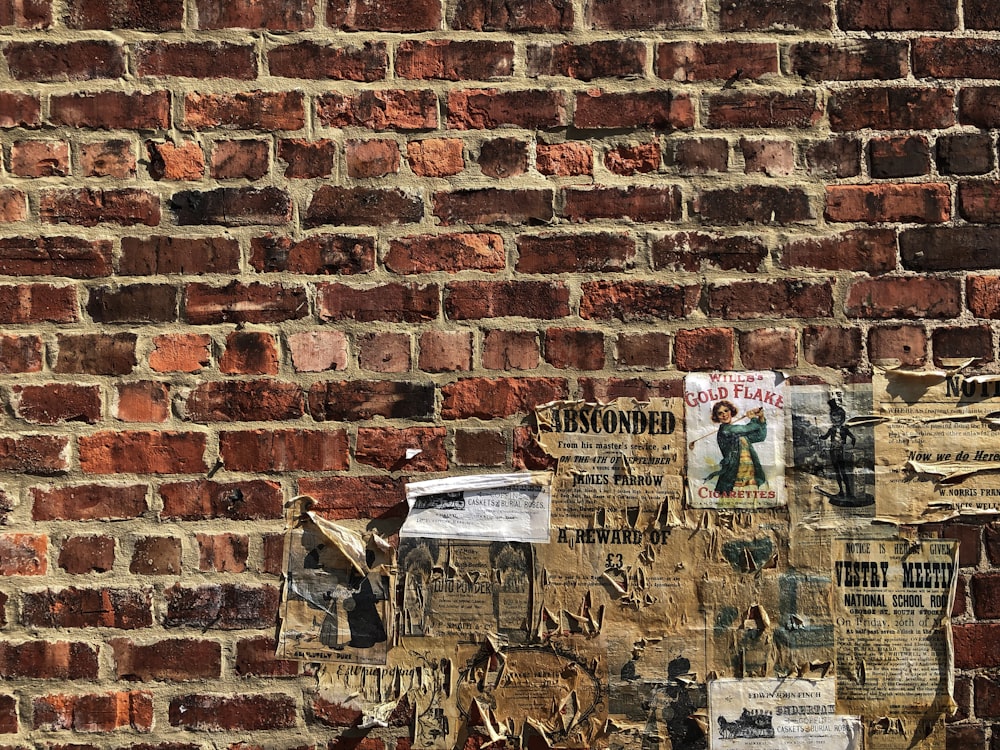 a brick wall with a bunch of newspaper on it