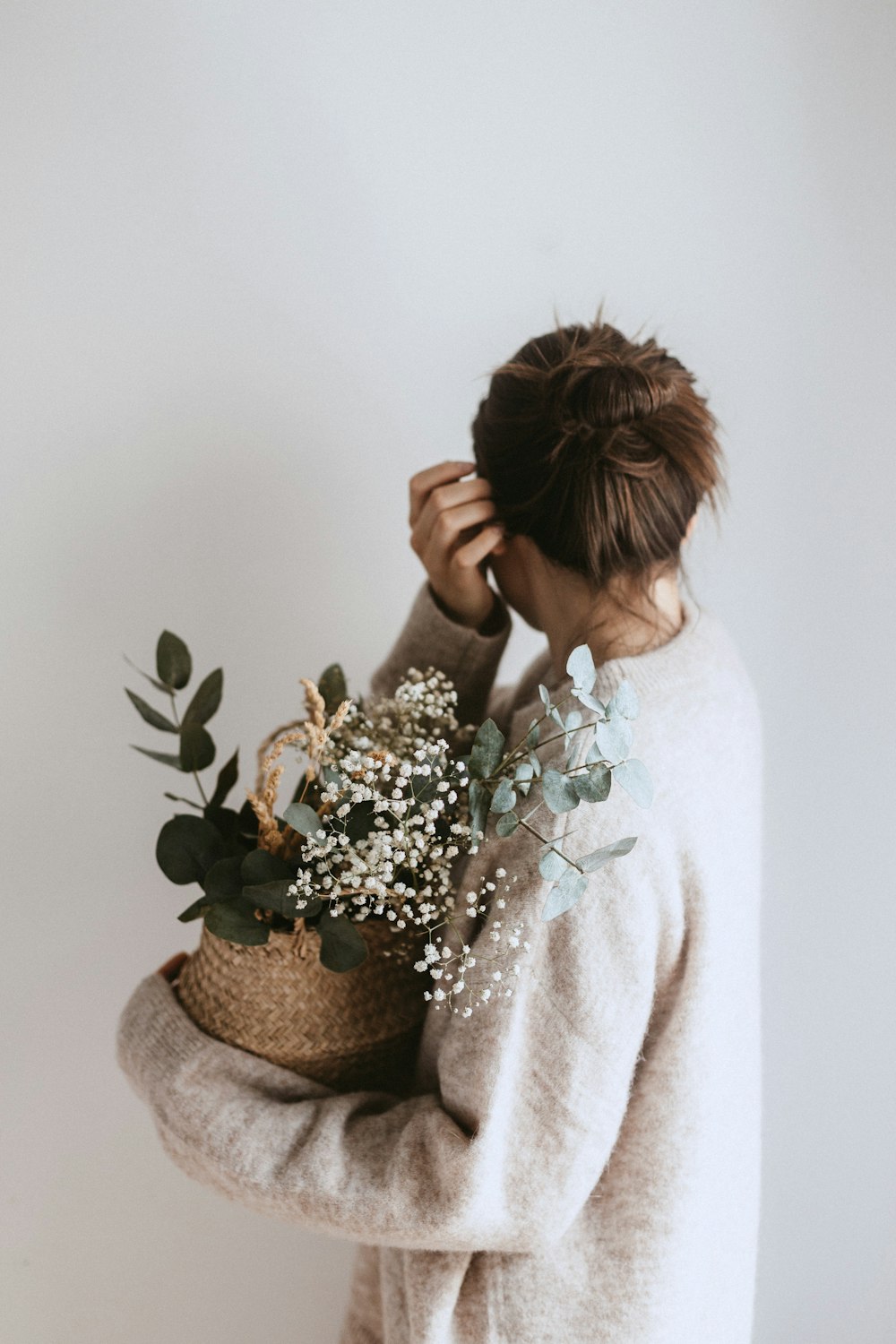 woman carrying white flower plant