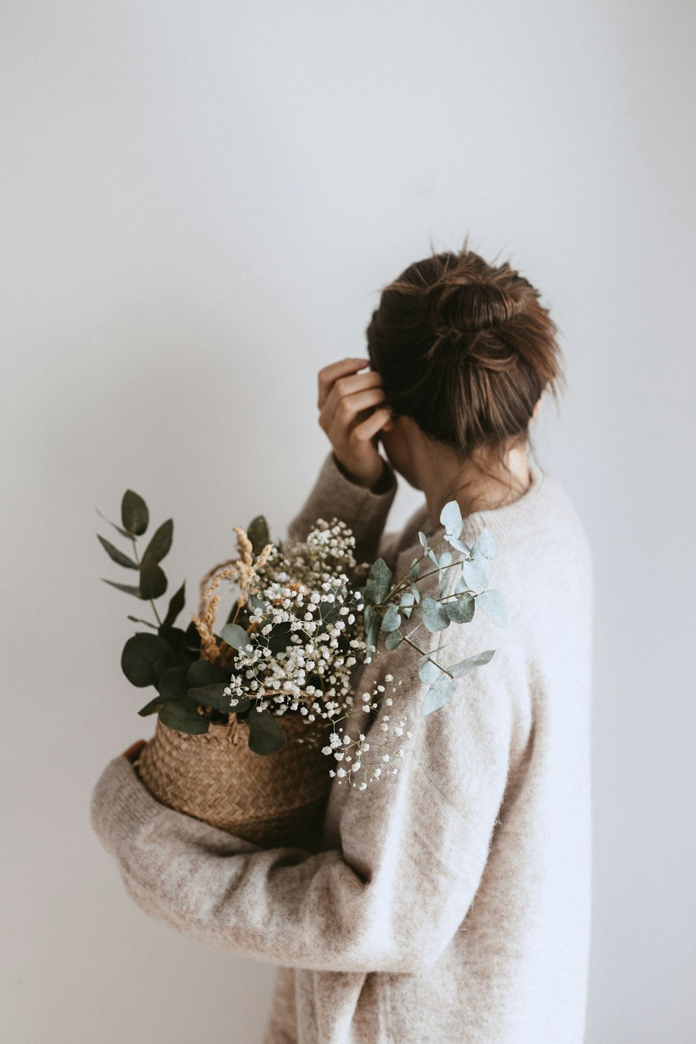Femme portant une plante à fleurs blanches