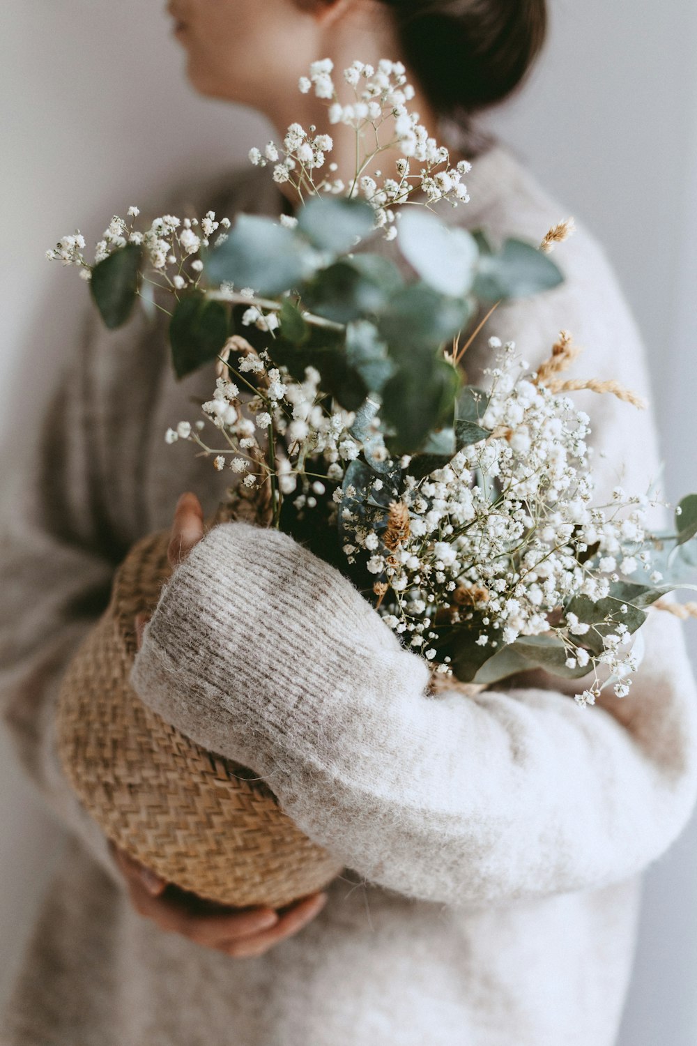 Femme tenant une plante à fleurs blanches