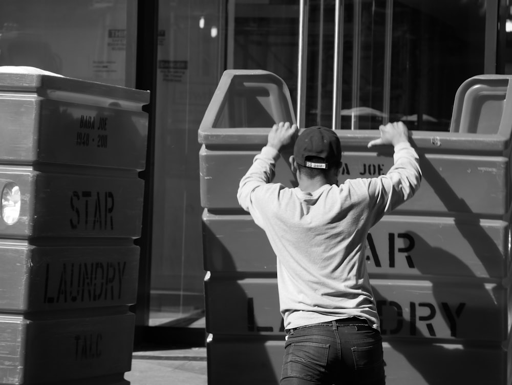 grayscale photo of man wearing long-sleeved shirt holding Star Laundry box