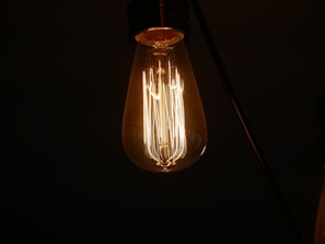 A vintage-style filament bulb glowing inside a clear glass lamp