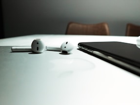 Wireless Bluetooth headphones resting on a red and white fabric background
