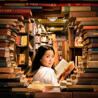 Portrait of Anahita Diamond surrounded by books and manuscripts in a cozy study.