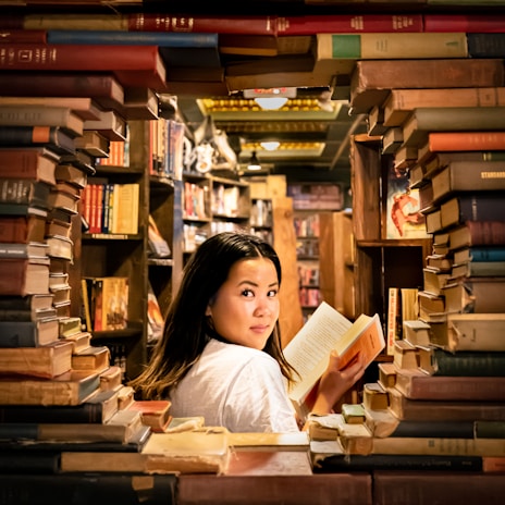 Portrait of the author in a cozy library setting, surrounded by books.