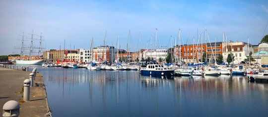 brown and white buildings and boat in Dunkerque France