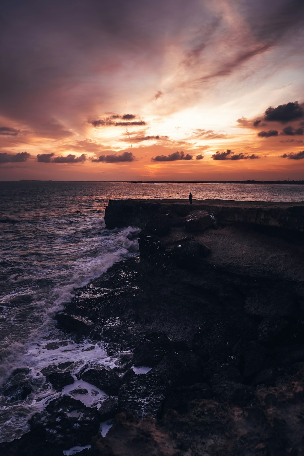 rocce attraverso lo specchio d'acqua durante il tramonto