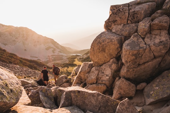 2 men standing besides chunk of rocks in Pirin National Park Bulgaria