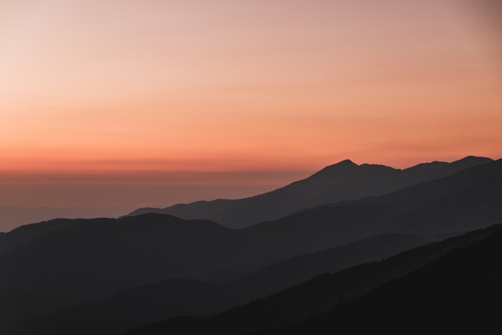 오렌지 하늘 아래 실루엣 산