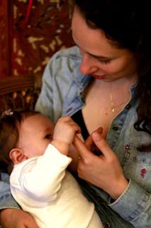A candid photo of a mother gently holding her child while they explore colorful educational materials together.