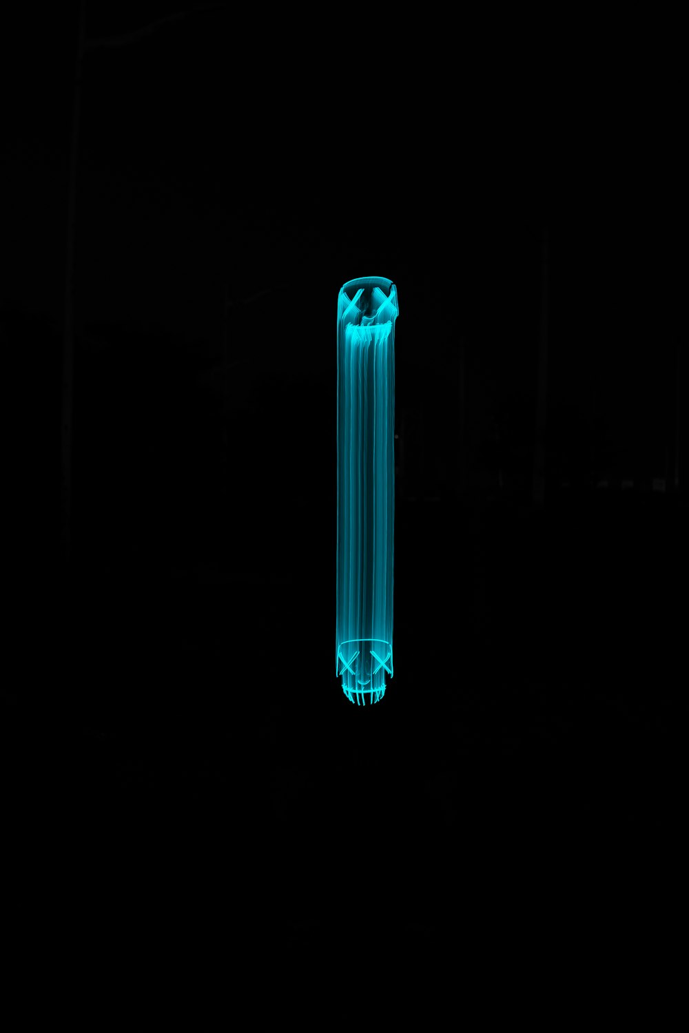 a blue tube is lit up in the dark