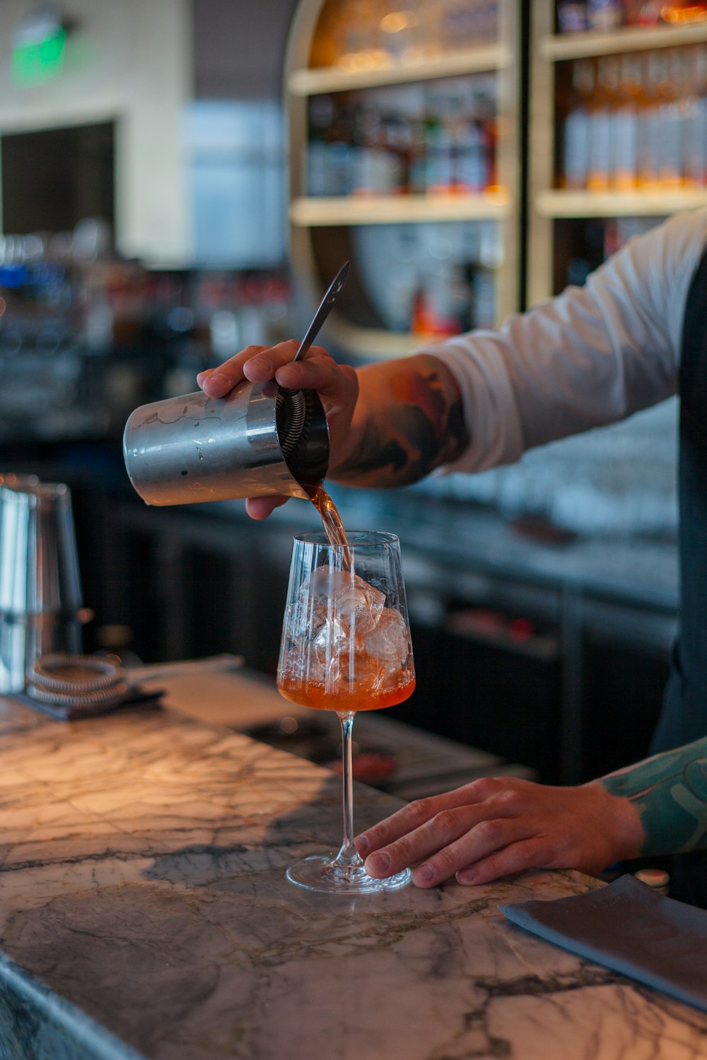 person pouring a liquid on wine glass