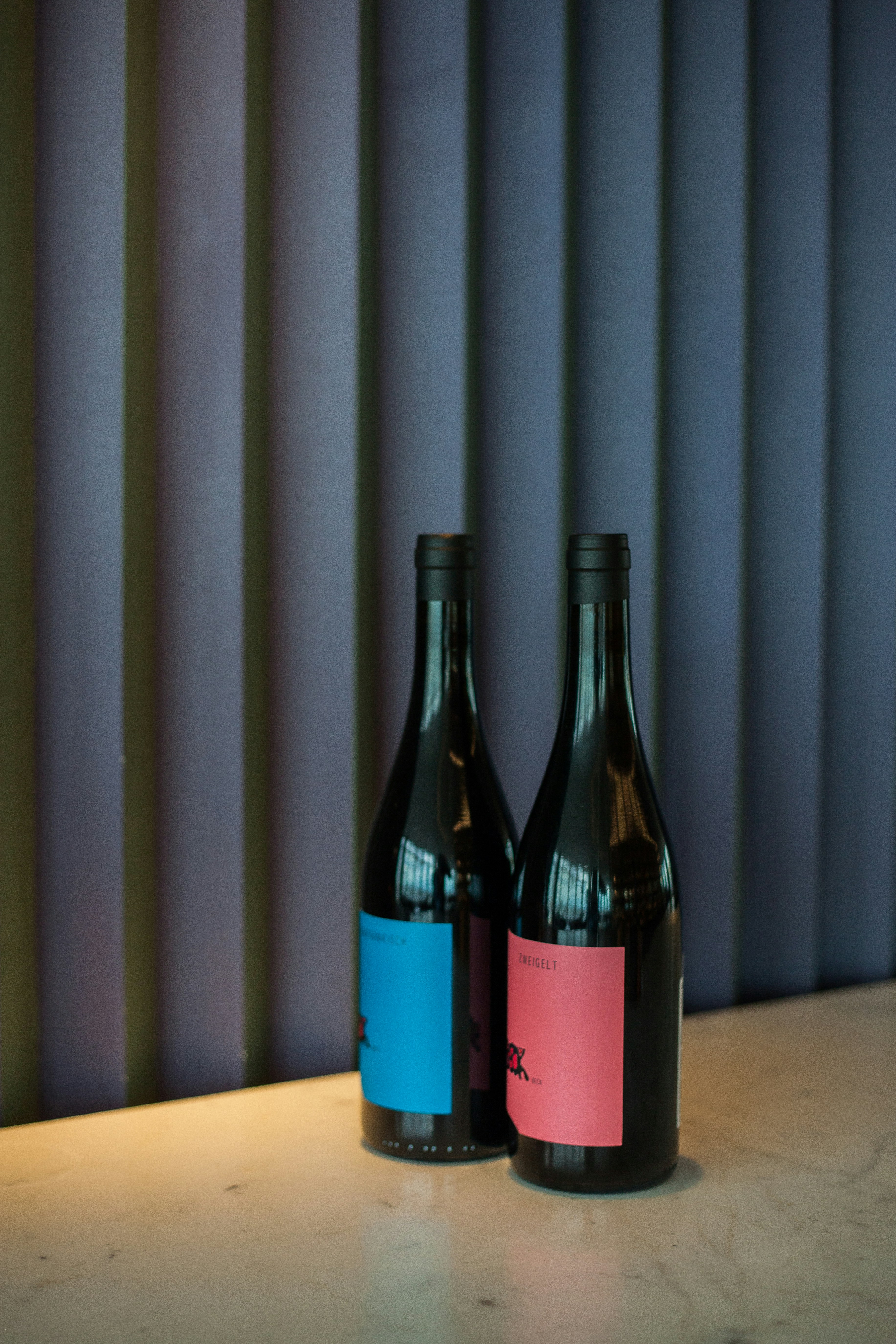 two blue and pink labeled wine bottles
