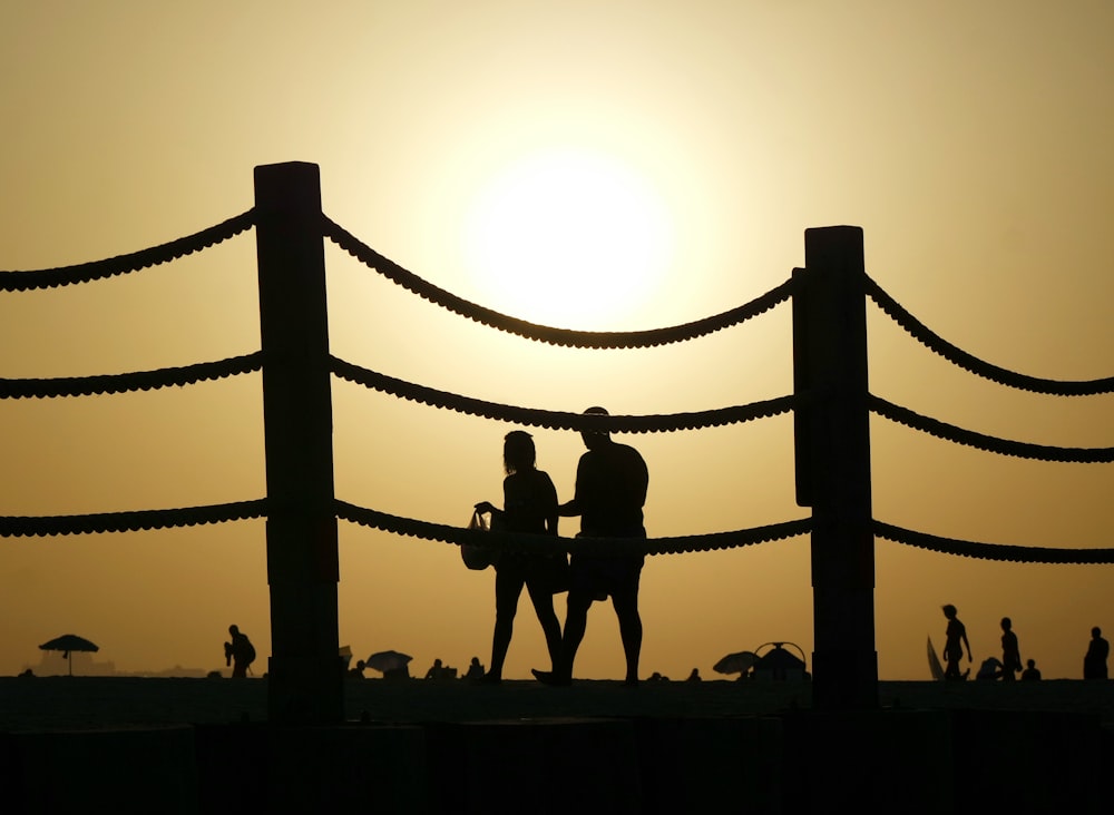 two people walking beside fence