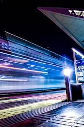 a train traveling past a train station at night