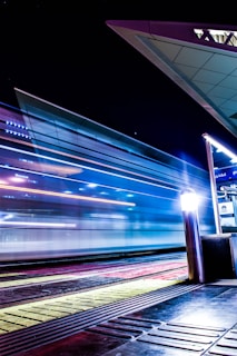 a train traveling past a train station at night