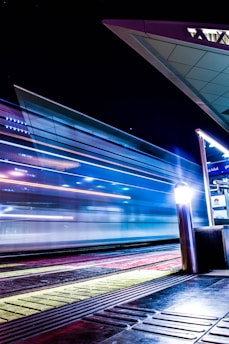a train traveling past a train station at night