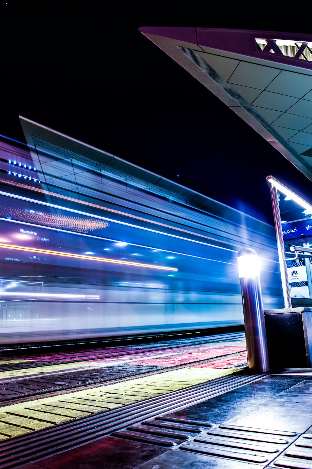 a train traveling past a train station at night