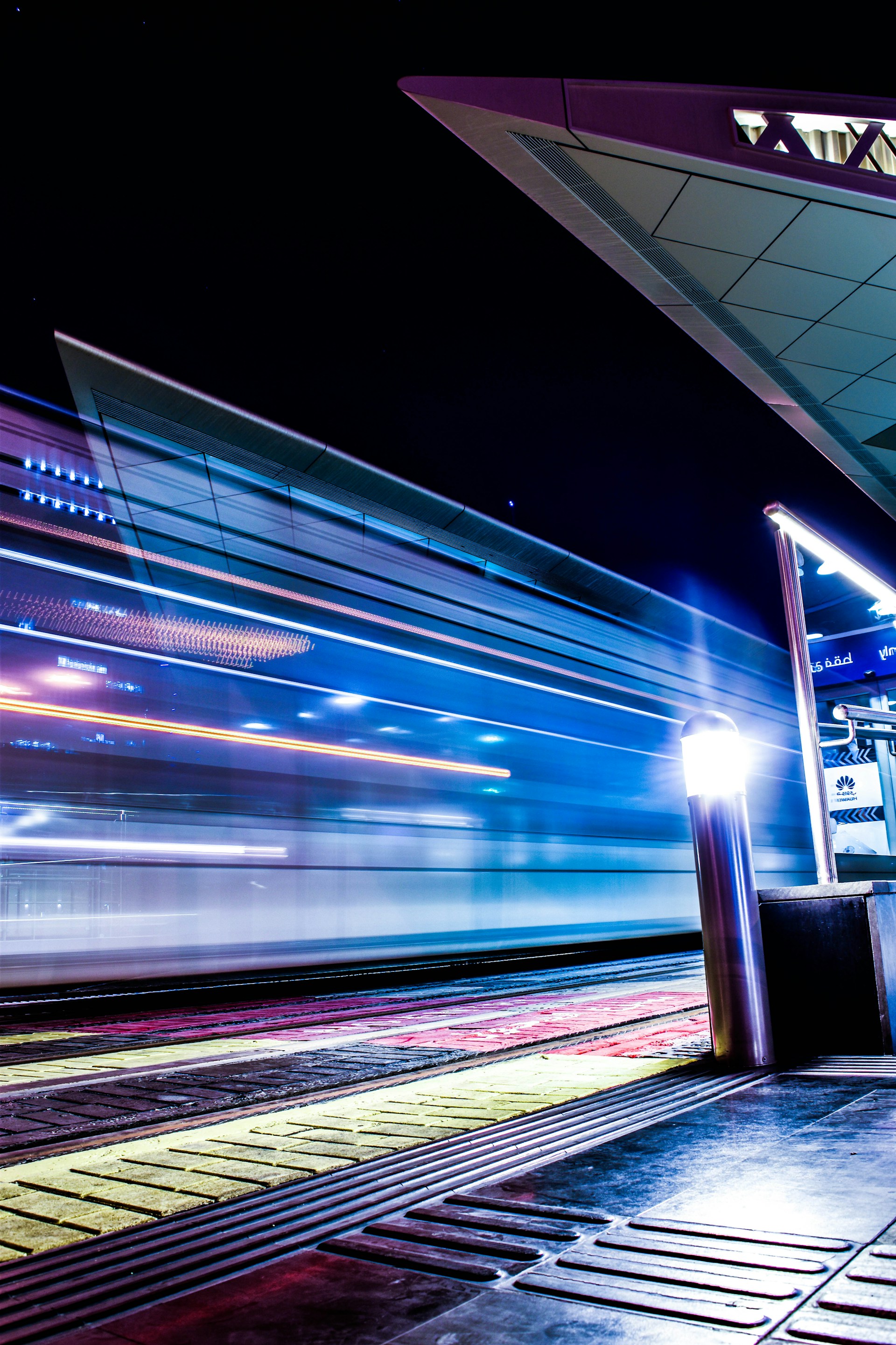 a train traveling past a train station at night